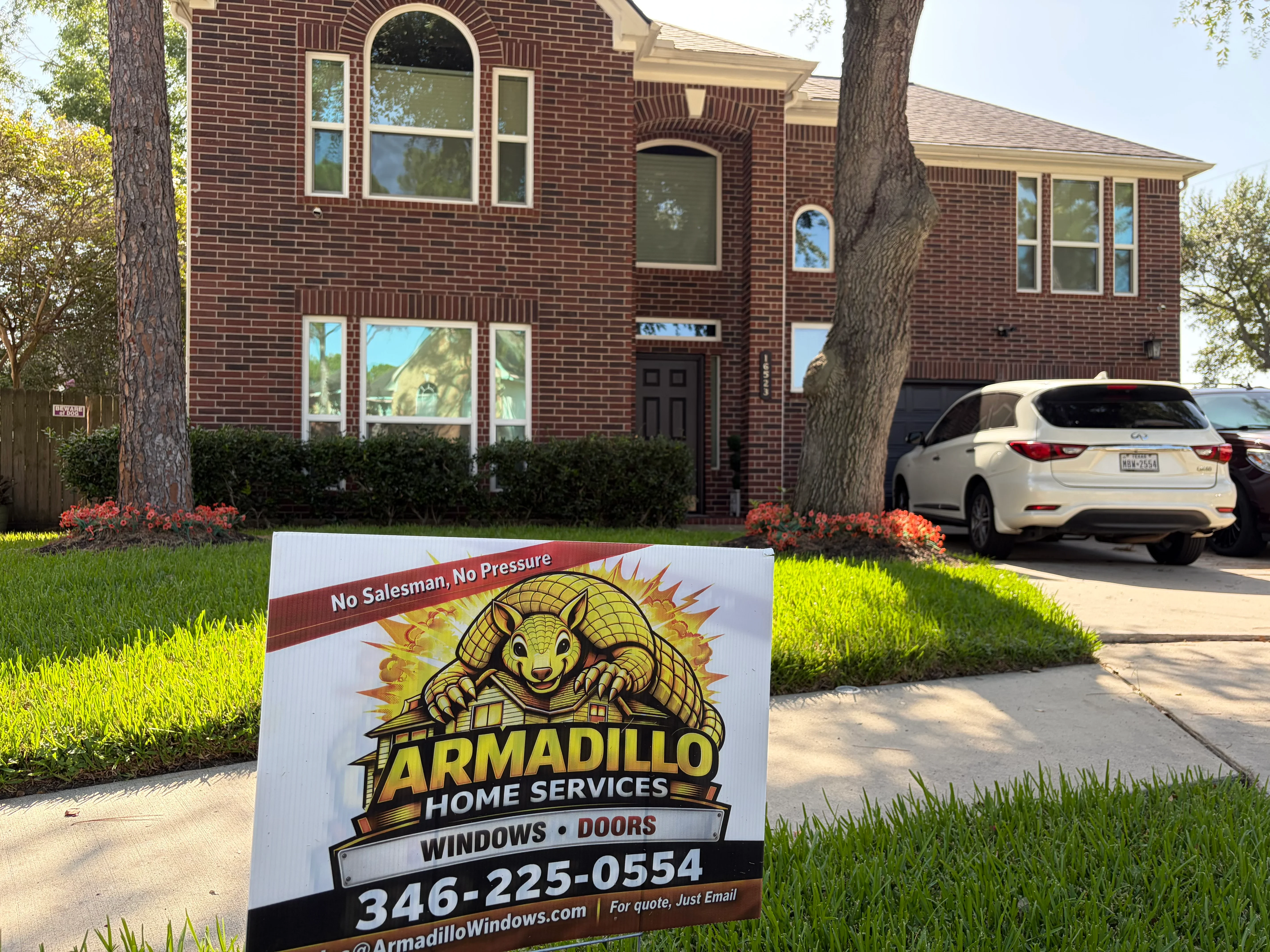 New energy-efficient windows installed on two-story brick home with arched and rectangular frames