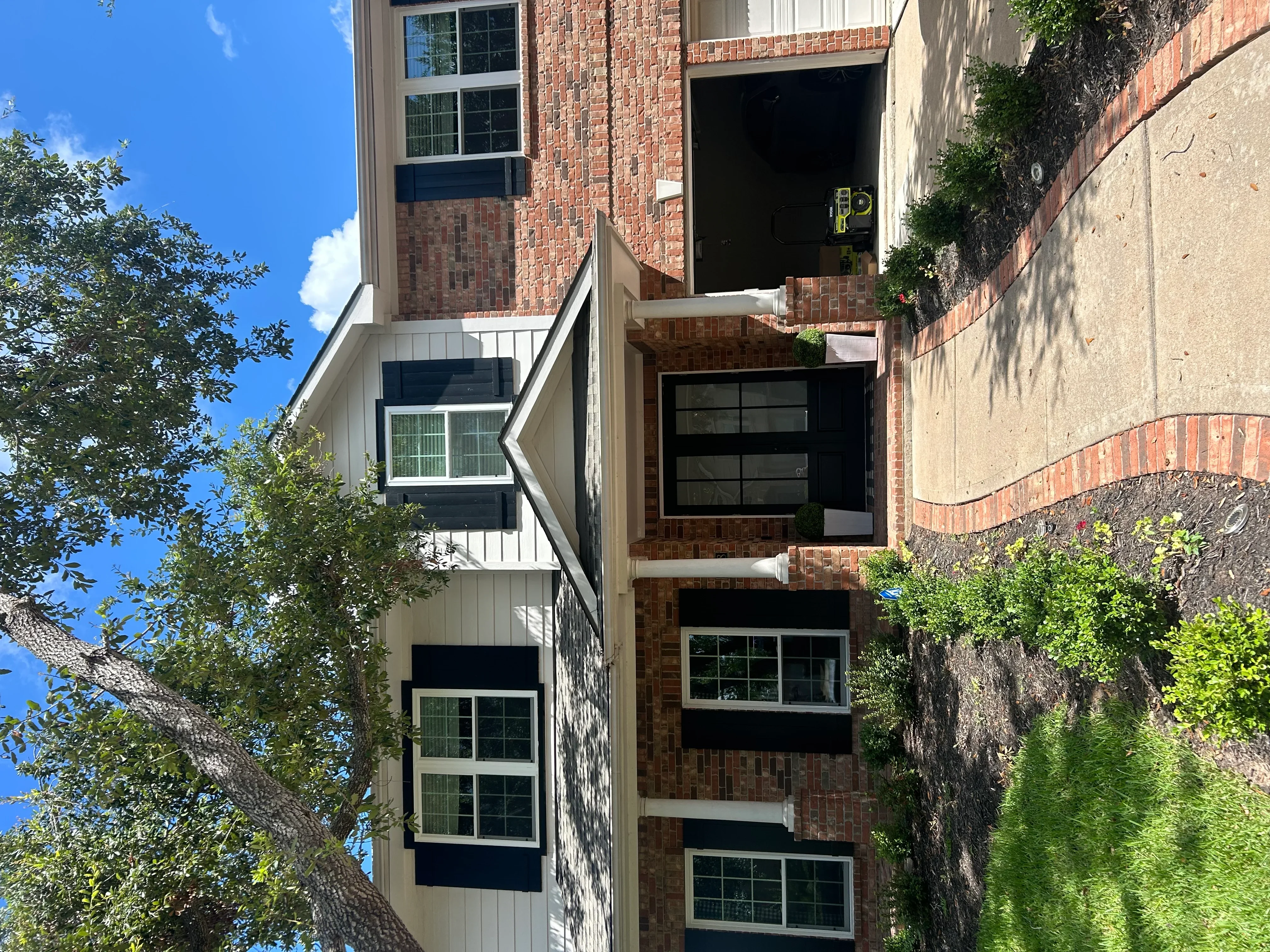 Multi-story brick building with newly installed dark-framed windows on three levels